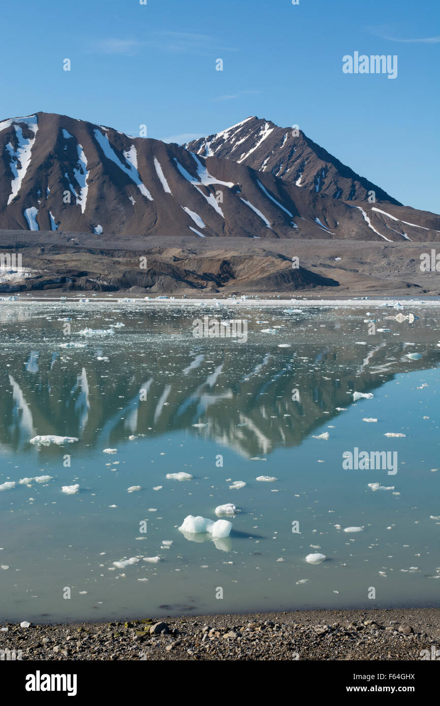 Norway, Barents Sea, Svalbard, Spitsbergen. Calm bay and mountain landscape in front of 14th July Glacier. Stock Photo