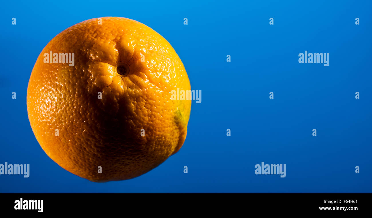 ORANGE on blue background, space for text layout, copyspace, text, font, fruit, food, vitamin C, colds, flu, flu infection, heal Stock Photo