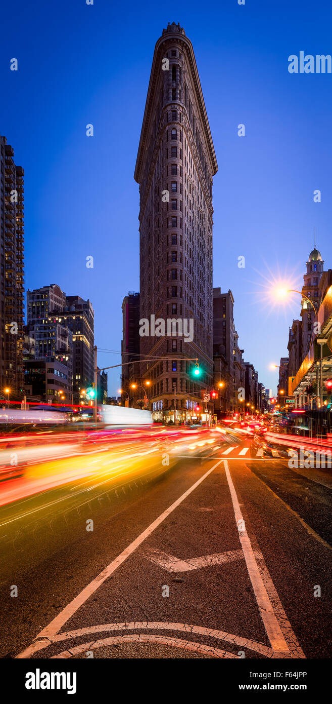 Flatiron Building with a clear blue sky and car light trails on 5th Avenue at dusk in Midtown Manhattan, New York City Stock Photo