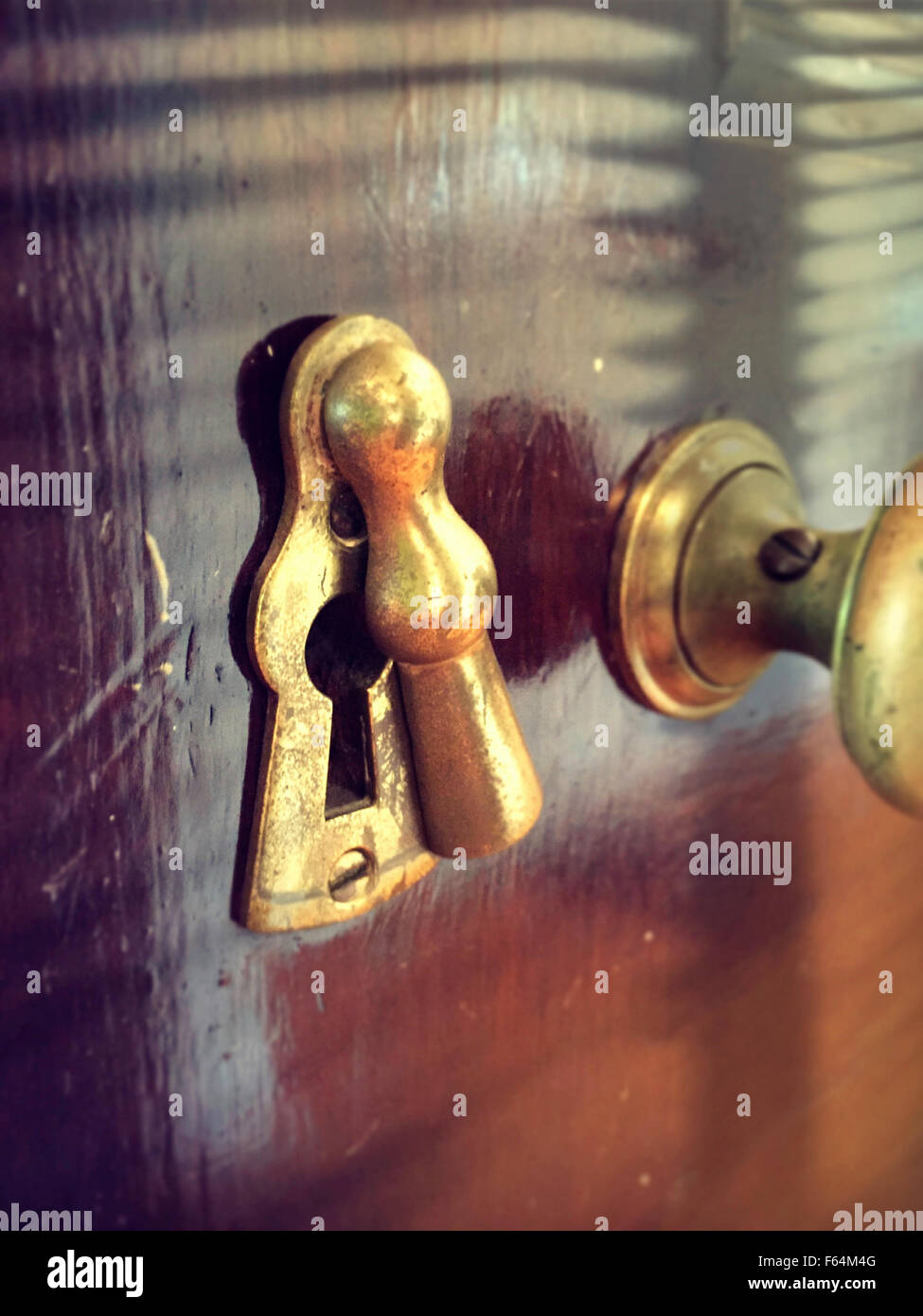 Brass Antique Doorknob and Keyhole with Escutcheon on Vintage Wooden Door Stock Photo