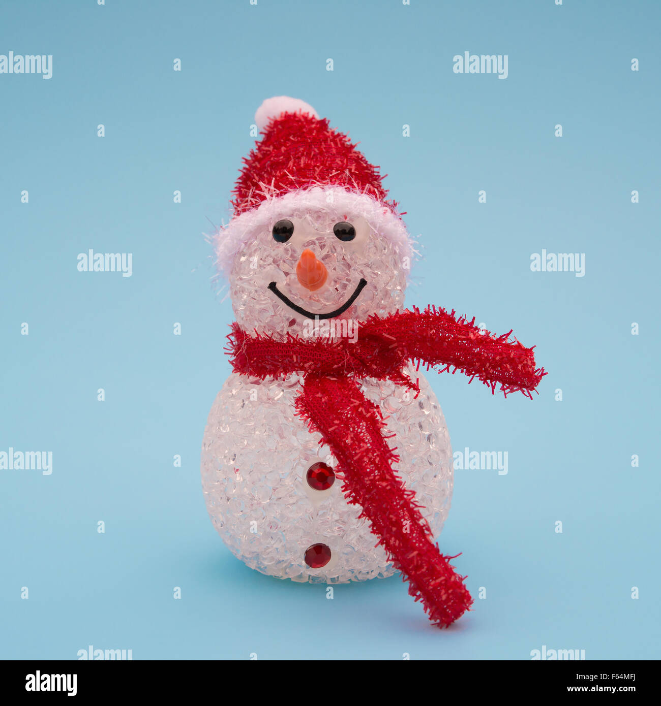 smiling toy christmas snowman with red scarf on blue Stock Photo