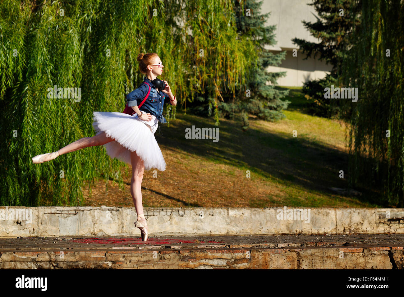 Sweet ballerina hipster on a walk in the autumn park. Girl to music on headphones. A girl wearing a tutu and Stock Photo - Alamy