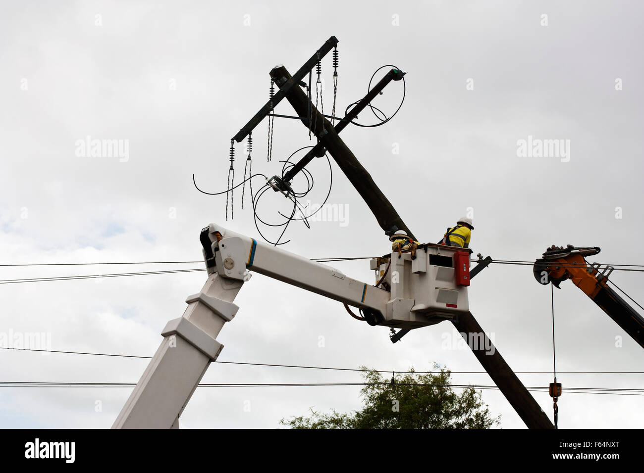 repair man fixing  and replacing a  electricity poll Stock Photo