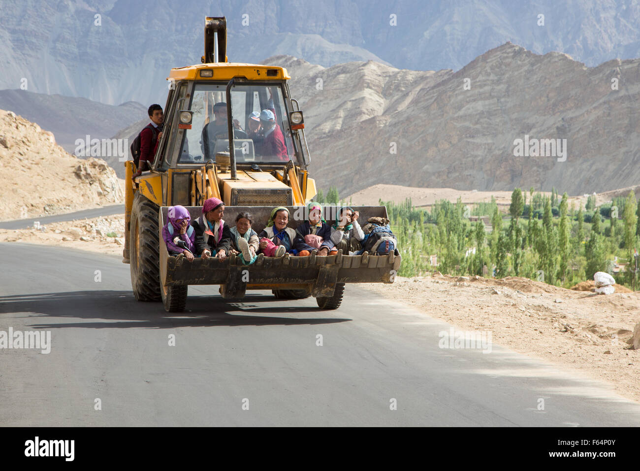 Leh, India - July 19 2014: Senior women using an earth moving machine as transport on the road in Ladakh, part of India Jammu & Stock Photo