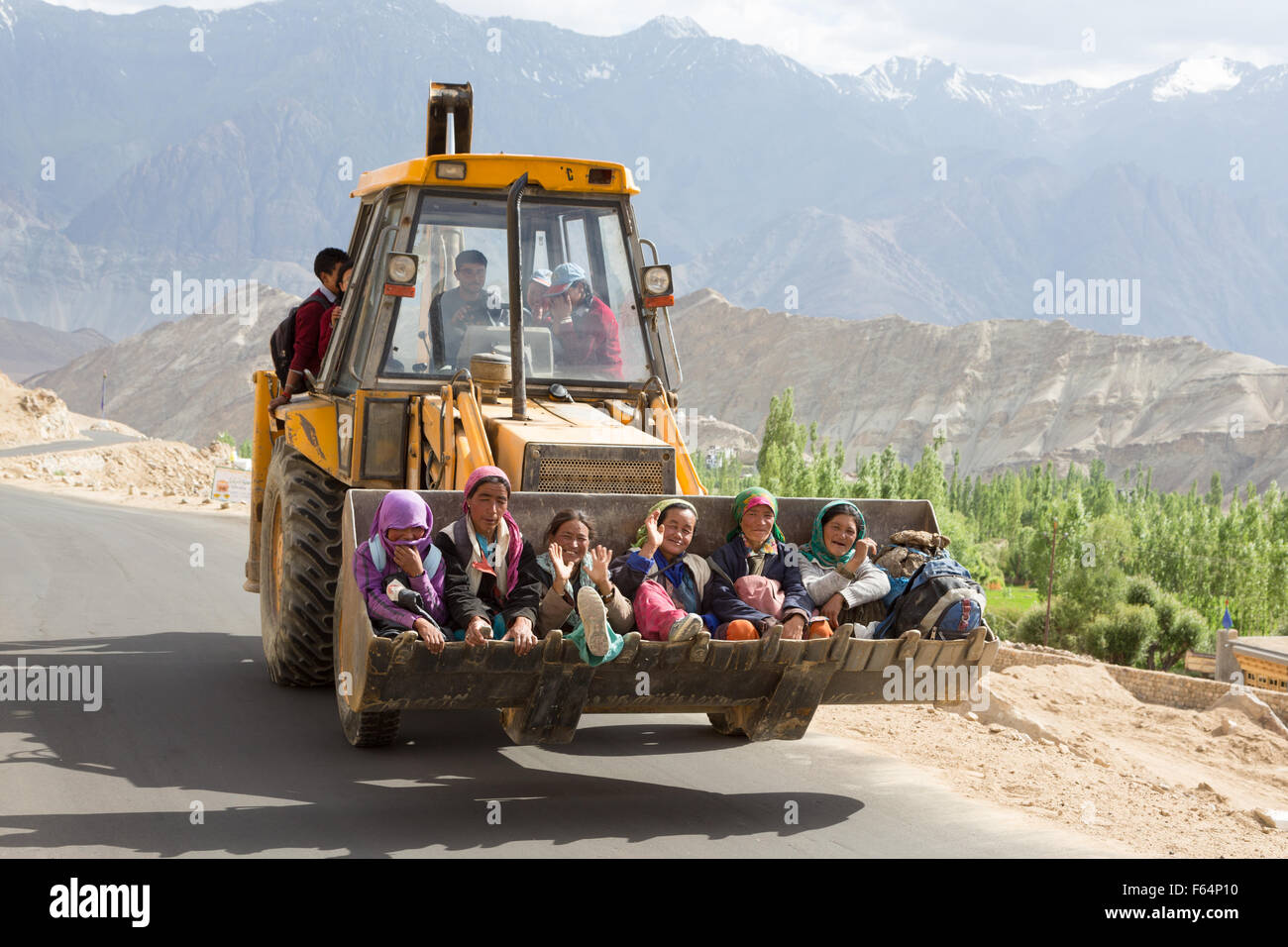 Leh, India - July 19 2014: Senior women using an earth moving machine as transport on the road in Ladakh, part of India Jammu & Stock Photo