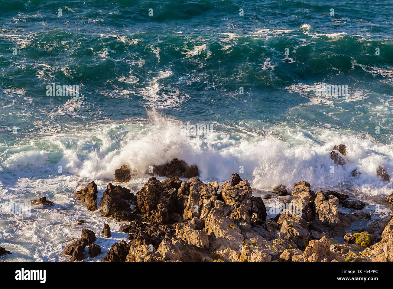 Stormy turbulent sea, waves hitting rocks at the coast. Stock Photo