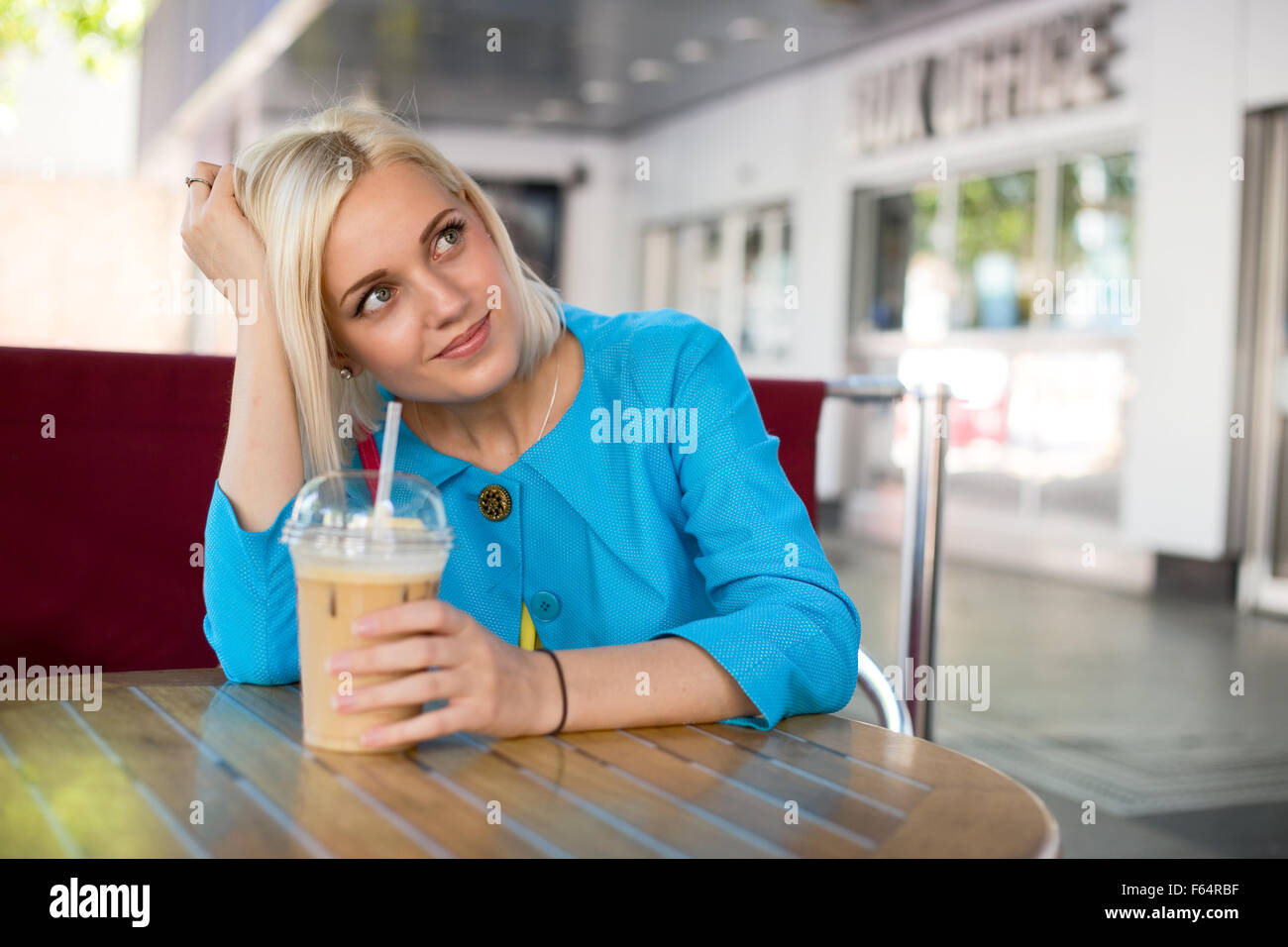 https://c8.alamy.com/comp/F64RBF/young-woman-sitting-at-a-caffee-shop-enjoying-a-frappe-F64RBF.jpg