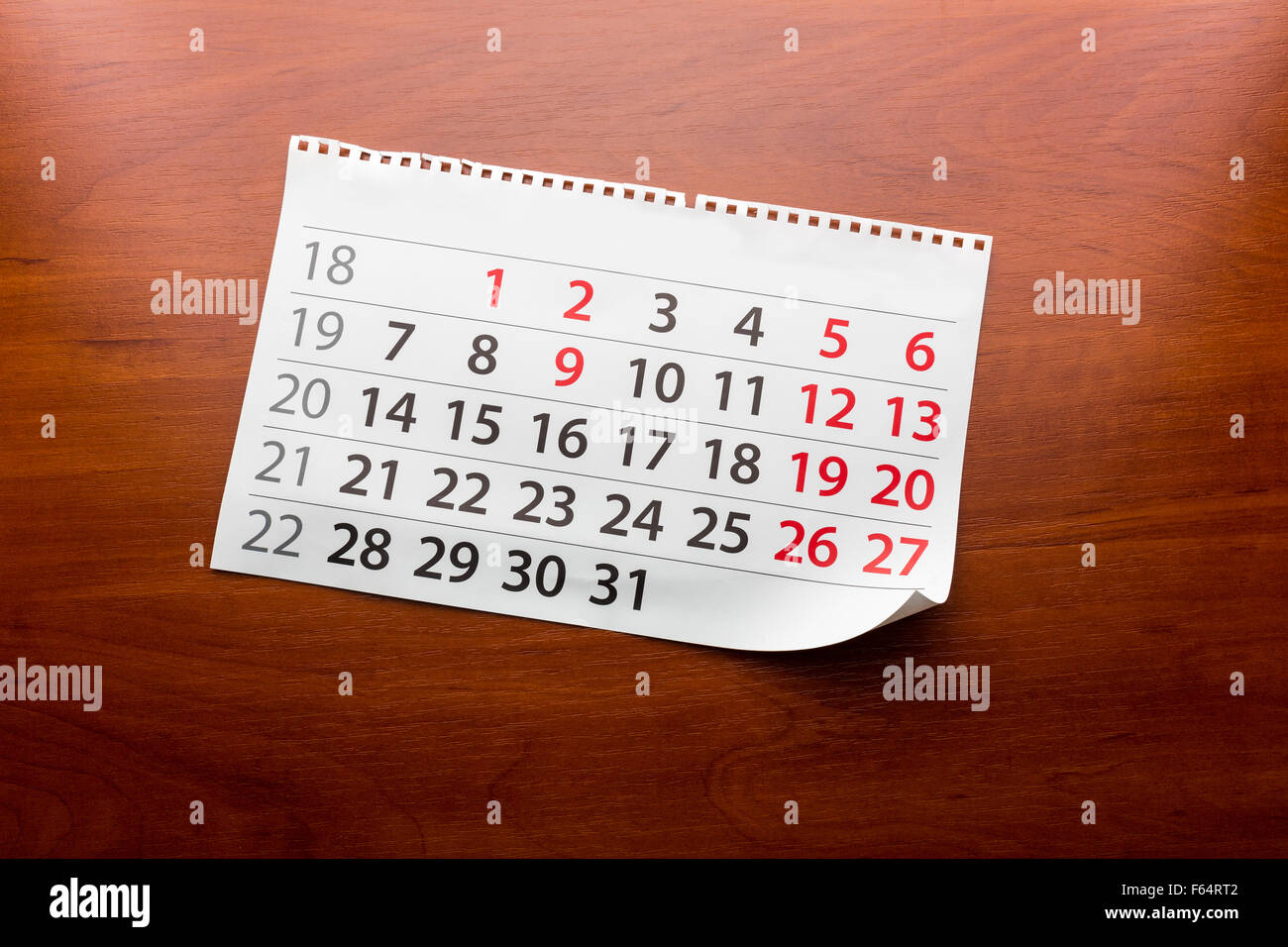 Page from calendar lays on the wooden table Stock Photo