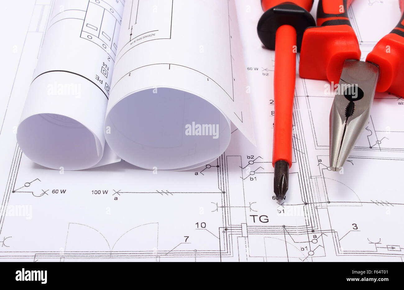 Rolls of electrical diagrams with work tools lying on construction ...