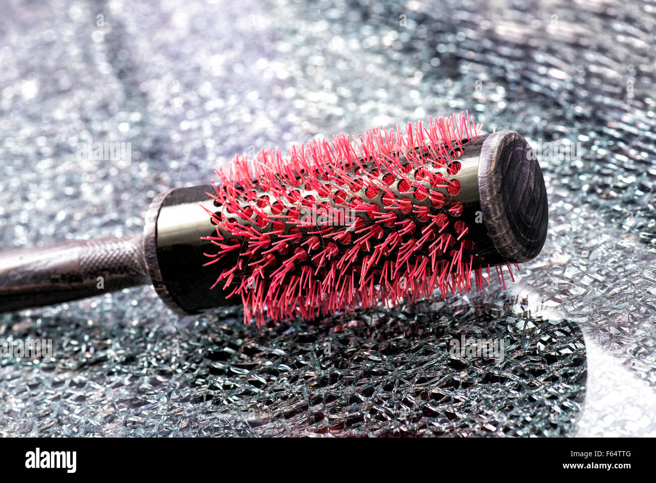 Professional hairbrush with red bristles lying on a textured table Stock Photo