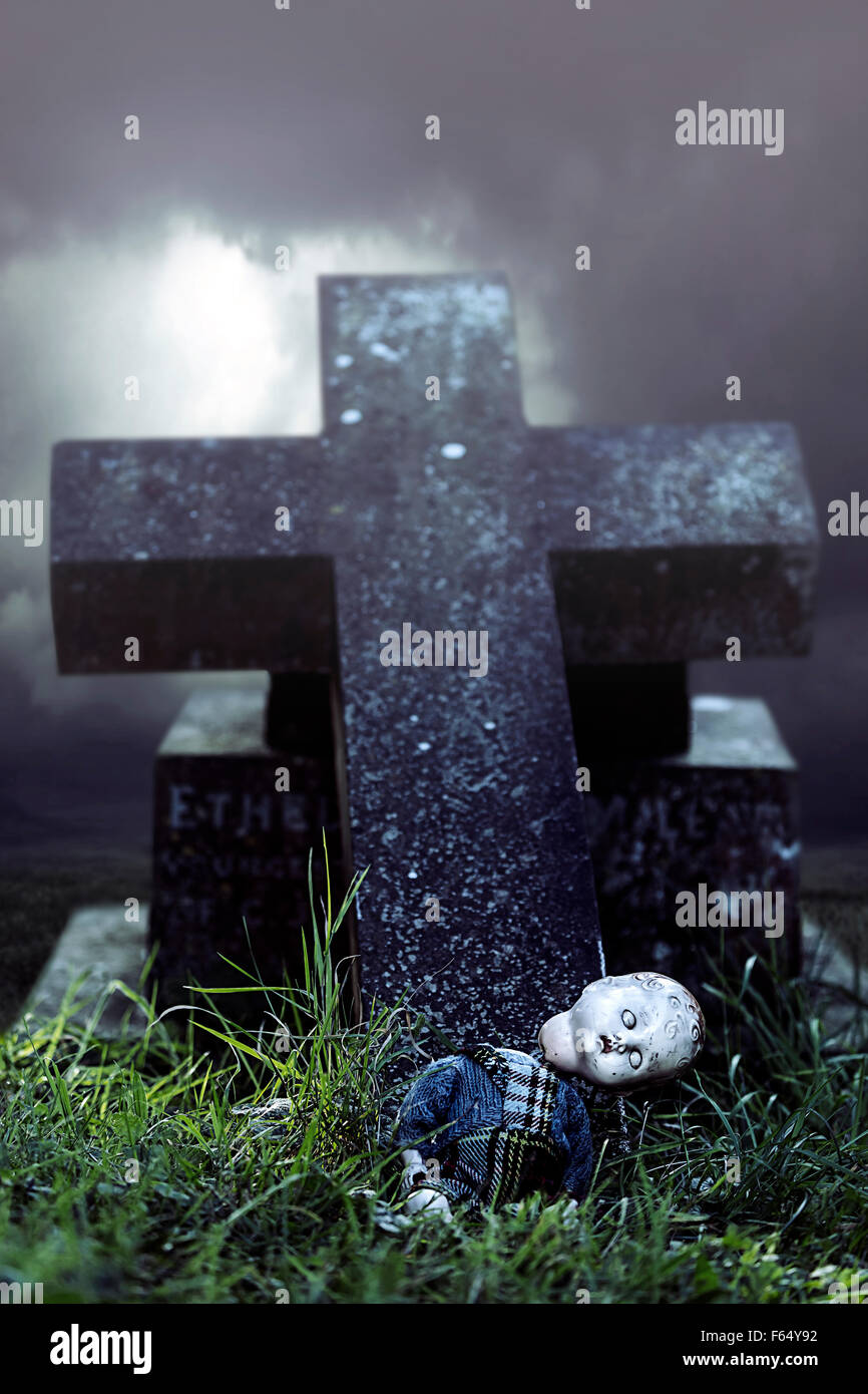 a broken doll on a grave Stock Photo
