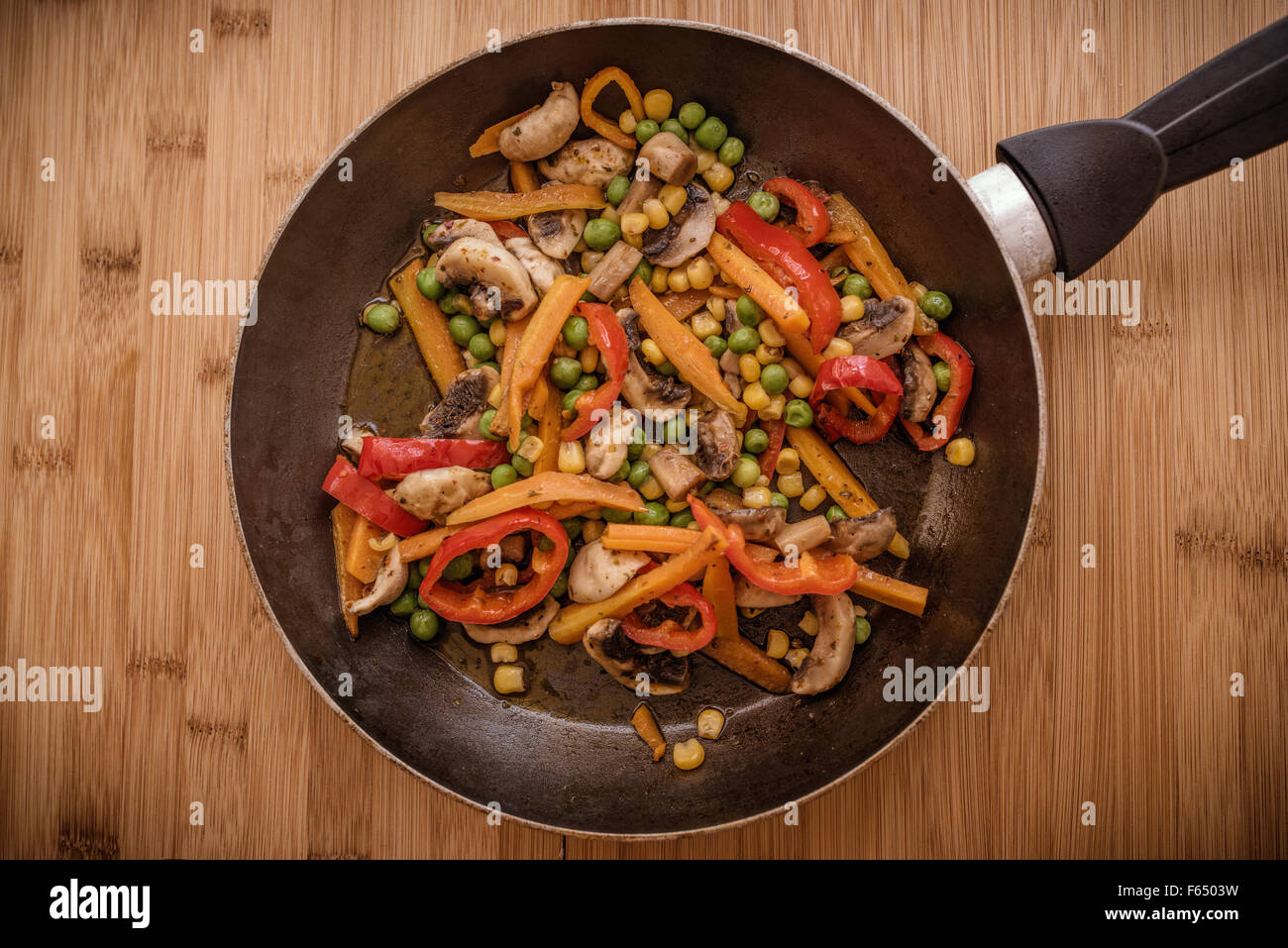 frypan and vegetables on wooden background Stock Photo