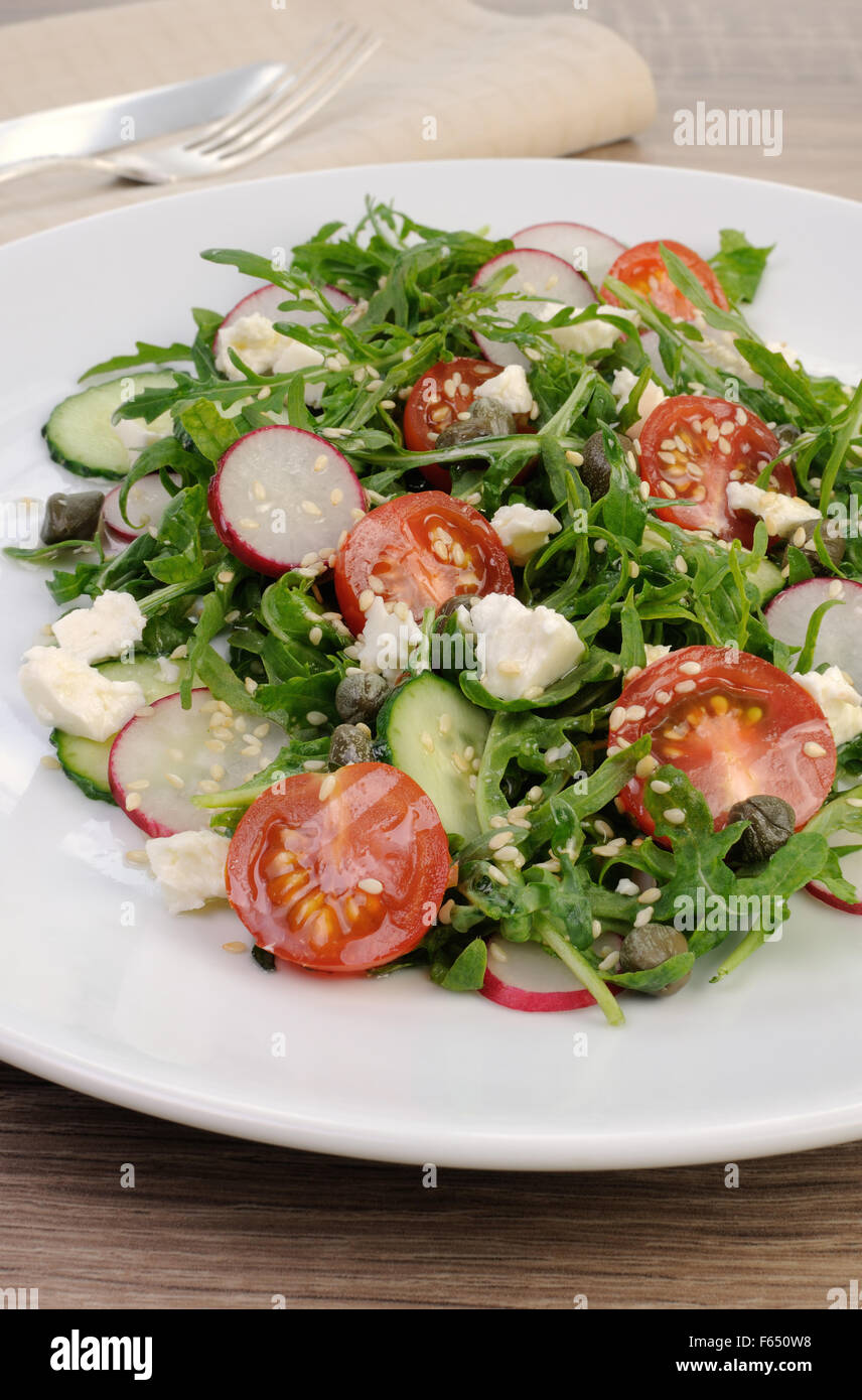 Vegetable salad with arugula, feta ,olive dressing and sesame seeds