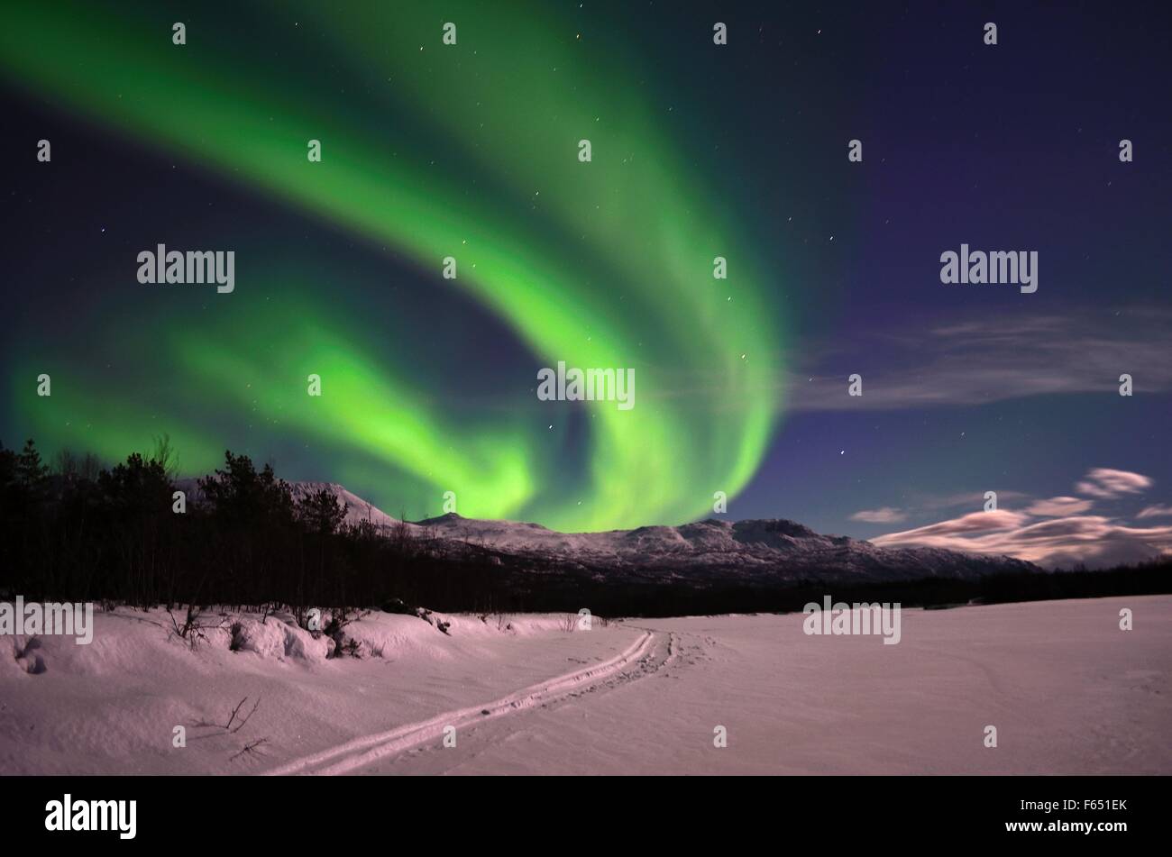 Aurora borealis on arctic winter night over snowy mountain on a frozen ...