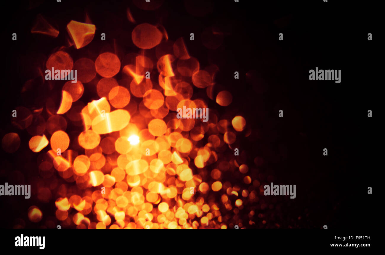 Defocused abstract golden lights on black background. Natural bokeh photo patten Stock Photo