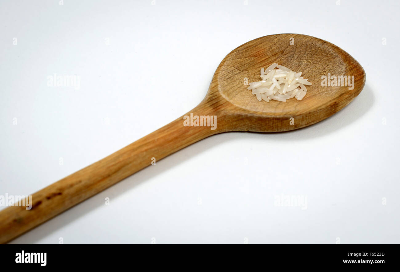 ILLUSTRATION - A small amount of raw rice on a wooden spoon. The photo was taken in Dresden (Saxony) on 13 March 2015. Photo: Thomas Eisenhuth Stock Photo