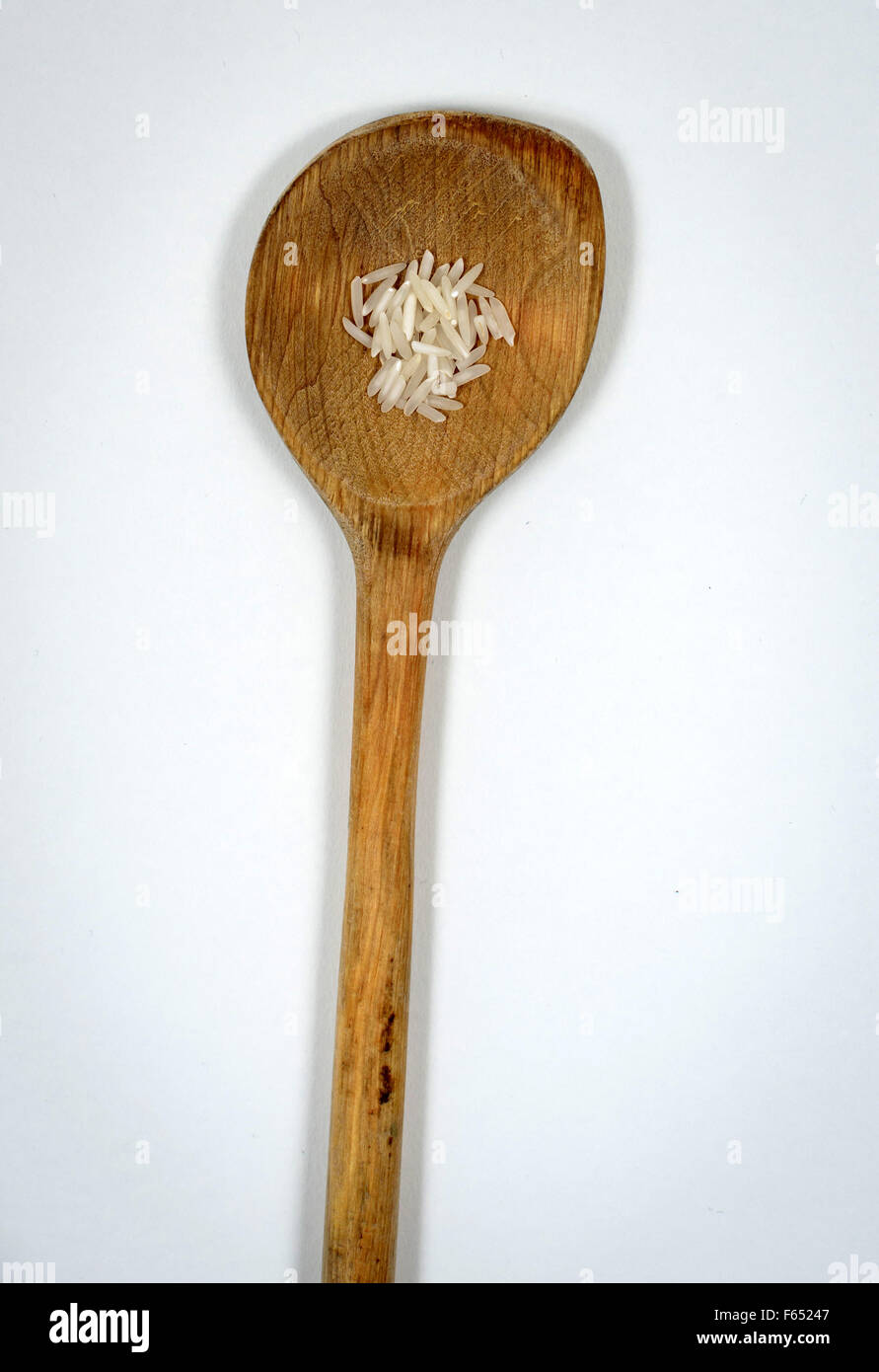 ILLUSTRATION - A small amount of rice on a wooden spoon. The photo was taken on 13 March 2015 in Dresden (Saxony). Photo: Thomas Eisenhuth Stock Photo