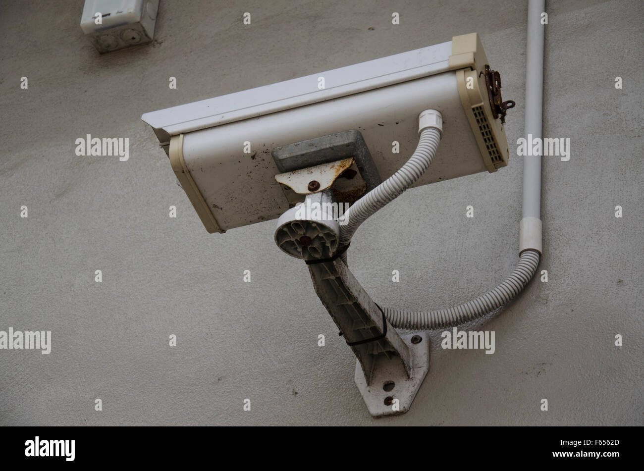 A surveillance or security CCTV camera mounted high on an exterior wall