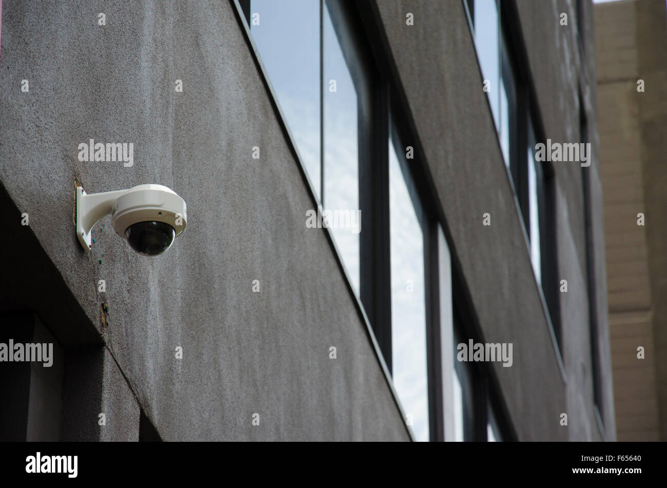 A surveillance or security CCTV camera mounted high on an exterior wall
