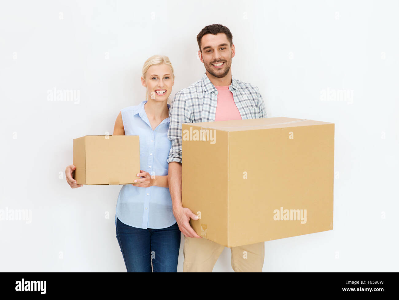 couple with cardboard boxes moving to new home Stock Photo - Alamy