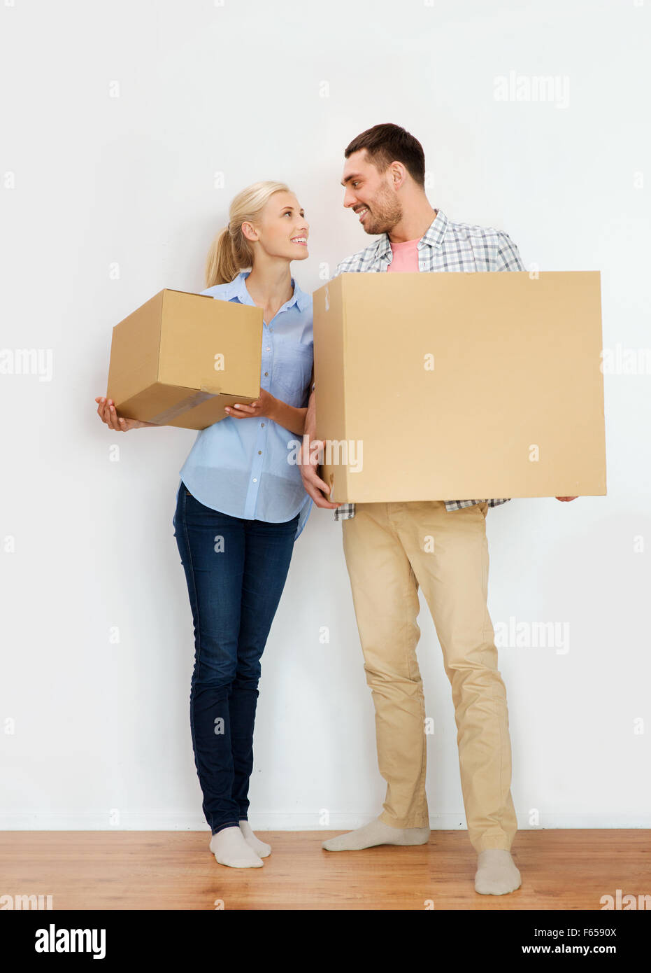 couple with cardboard boxes moving to new home Stock Photo - Alamy