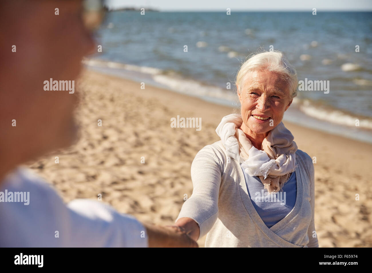 happy senior couple holding hands summer beach Stock Photo - Alamy