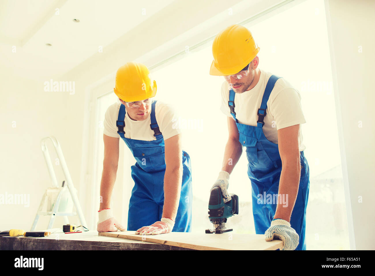 group of builders with tools indoors Stock Photo - Alamy