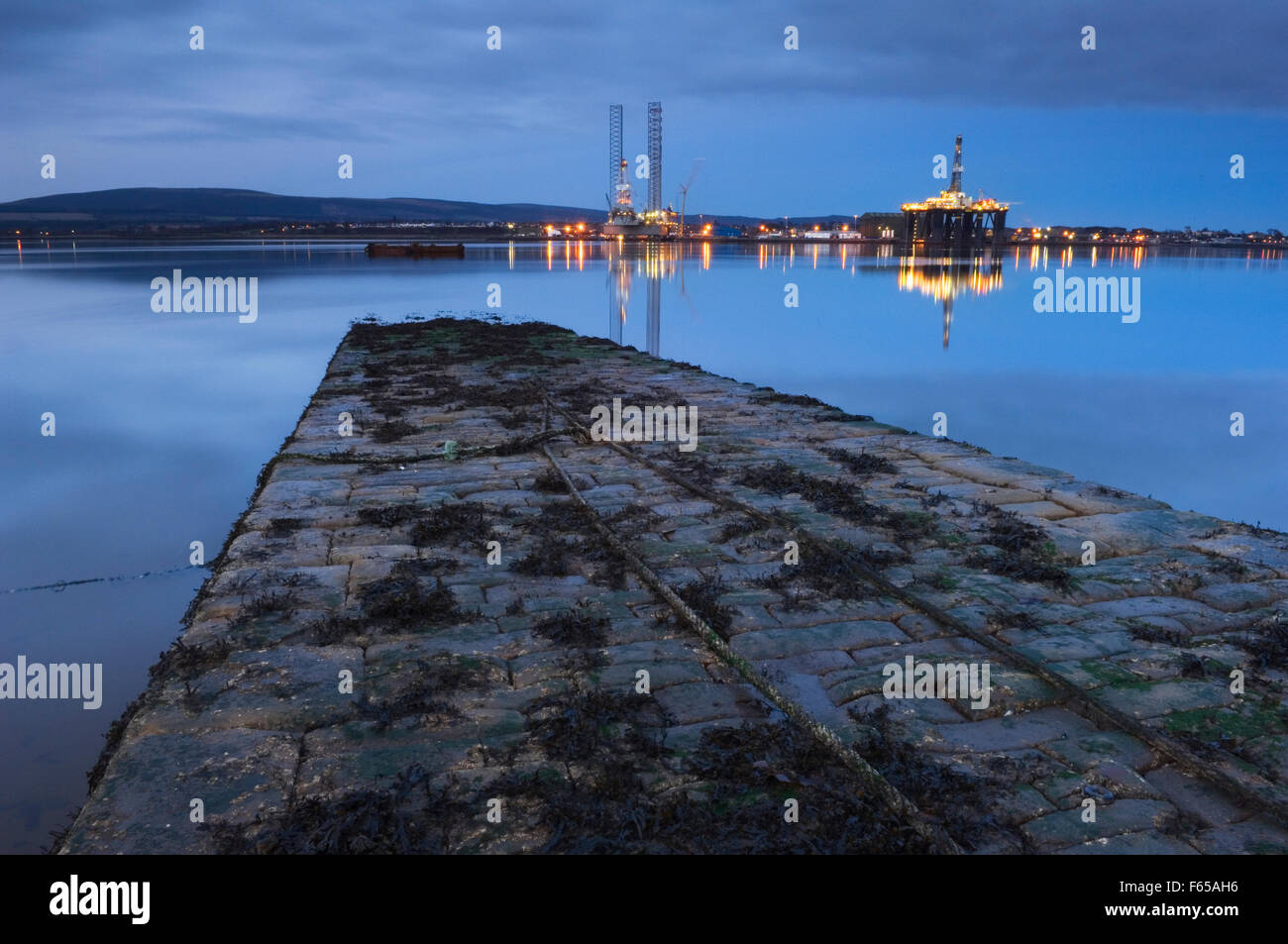 Invergordon with oil rigs at night from the slipway at Balblair on the Black Isle, Ross-shire, Scotland. Stock Photo