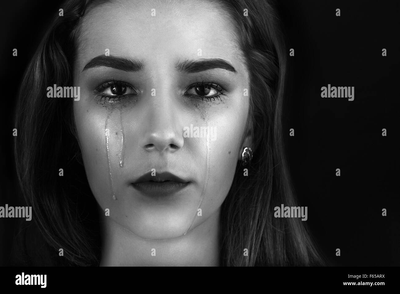 beautiful woman crying on black background, monochrome Stock Photo