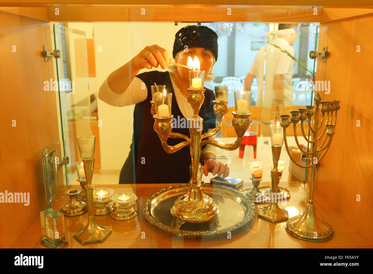Religious Jewish woman lights Shabbat candles in her home Stock Photo ...