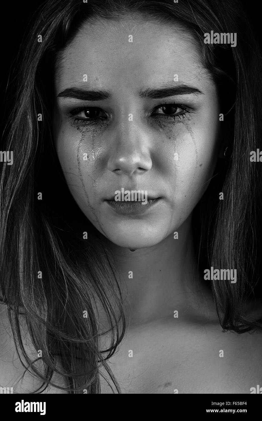 sad woman crying on black background, monochrome Stock Photo