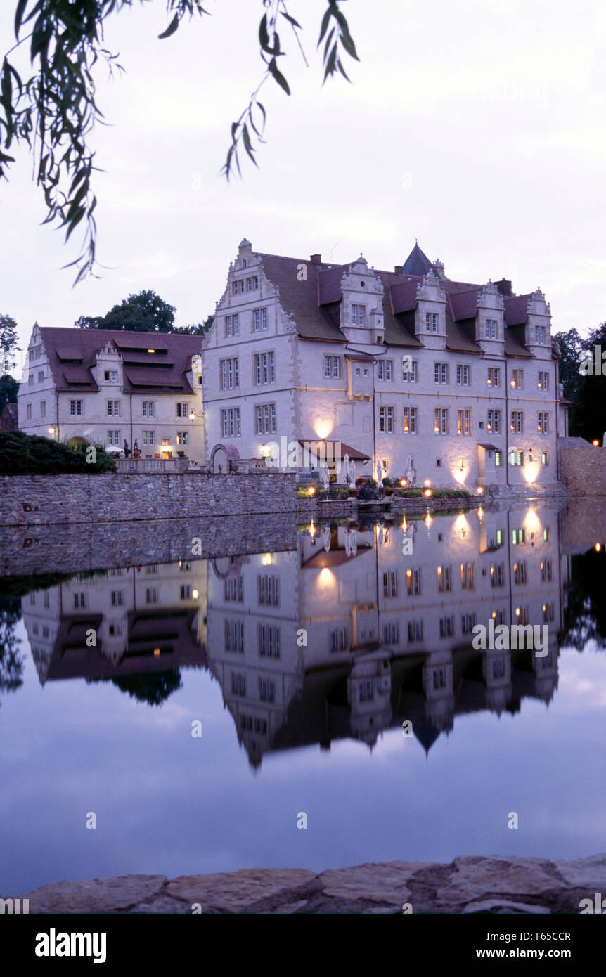 Reflection of Schloss hotel Munchhausen in pond at dusk Stock Photo