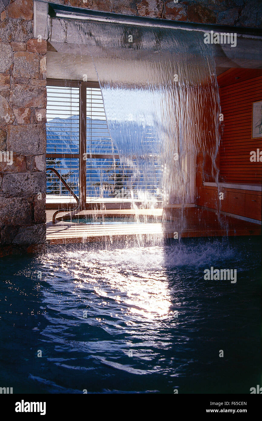 Swimming pools and artificial waterfall inside house Stock Photo