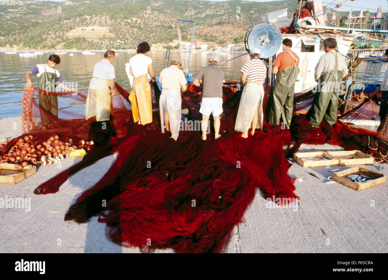 Fishermen organizing their fishing nets on pier in Platania, Italy Stock Photo