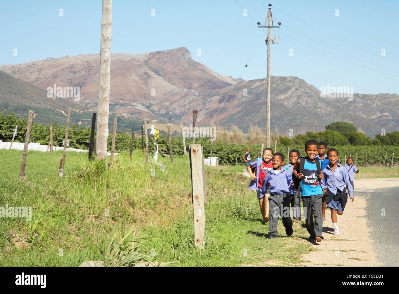 Happy African children running on roadside, South Africa Stock Photo
