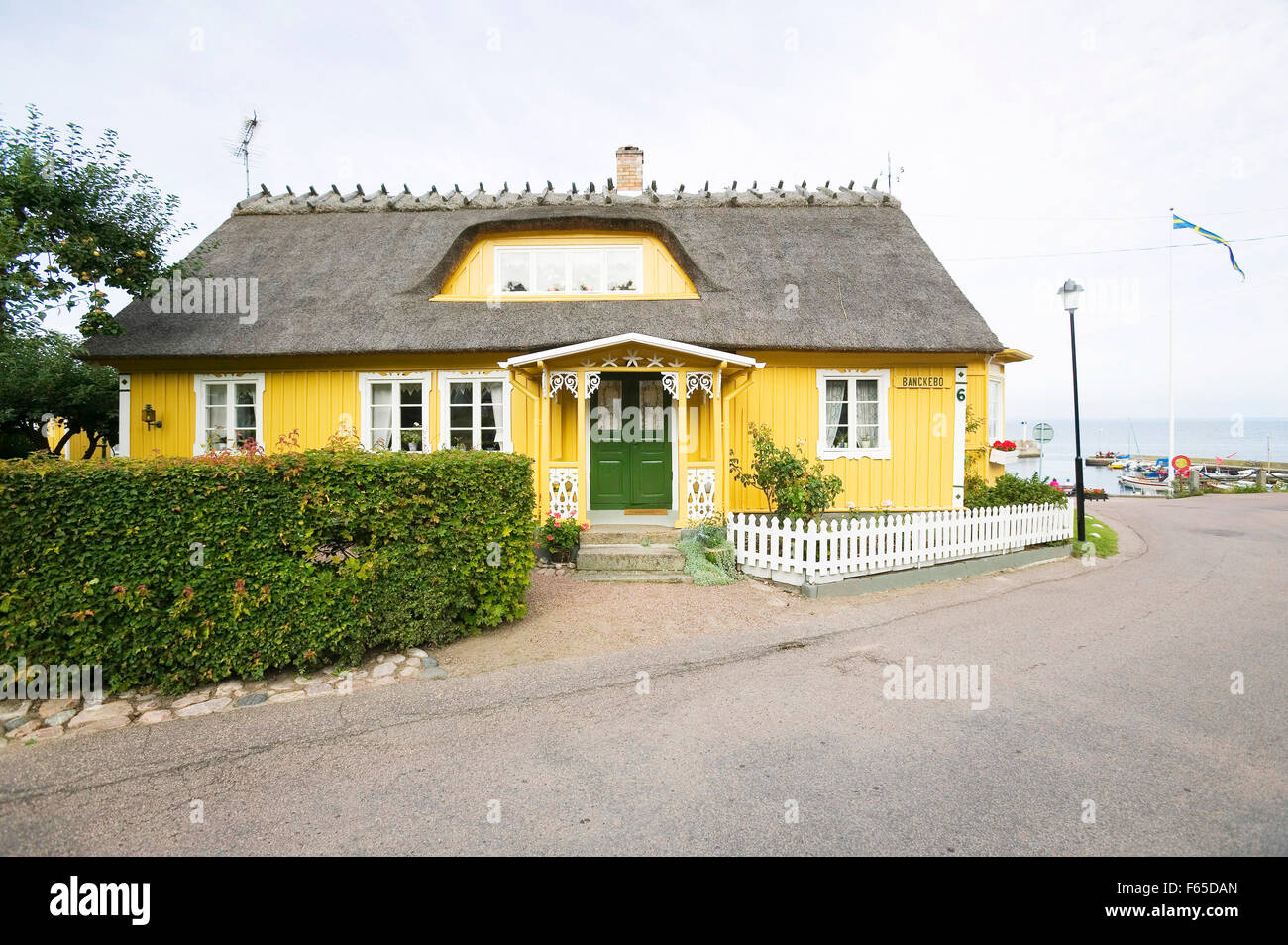 Yellow painted house at harbour in fishing village Arild, Oresund ...