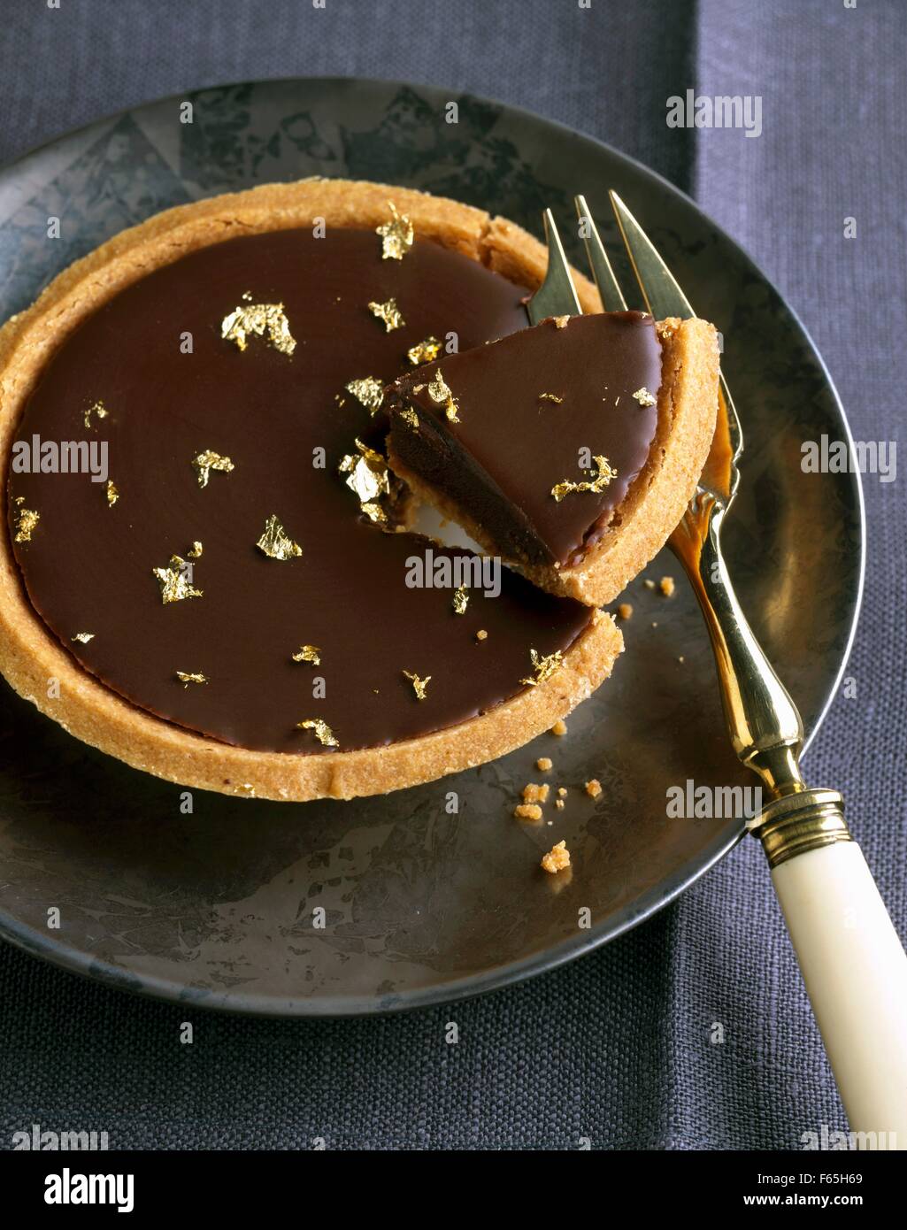Dark chocolate tartlet with gold flakes Stock Photo