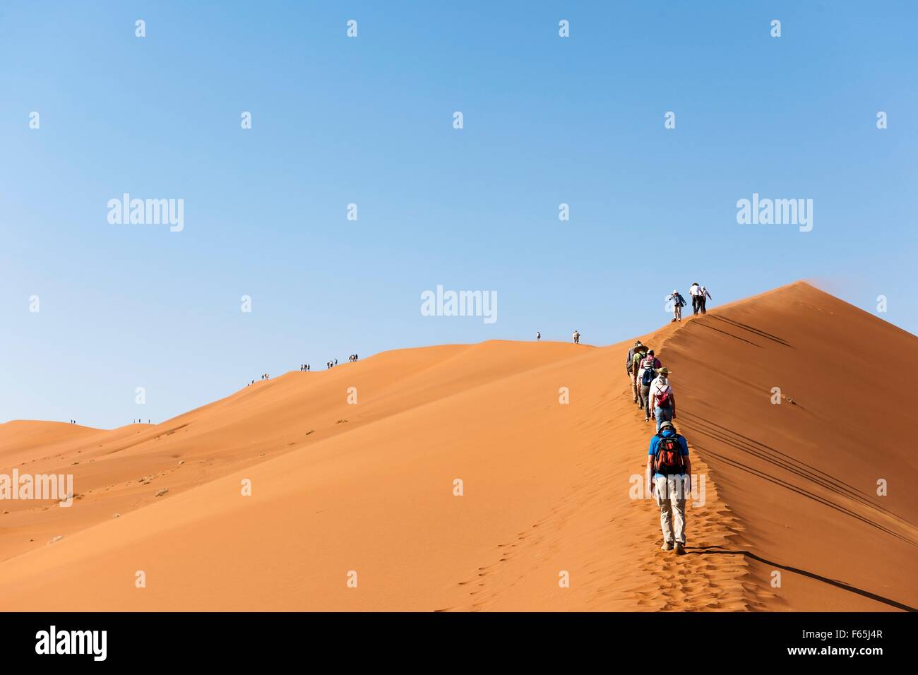 Tourists on the sand dunes at Sossusvlei in the Namibian desert – part ...