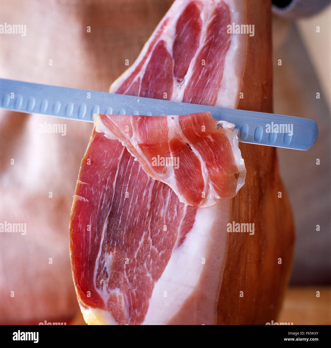 cutting raw ham Stock Photo Alamy