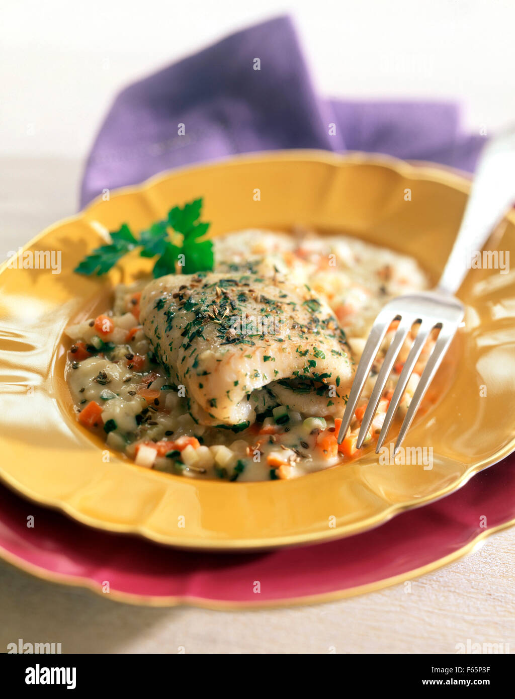 Steamcooked halibut with diced vegetables and creamy sauce Stock Photo