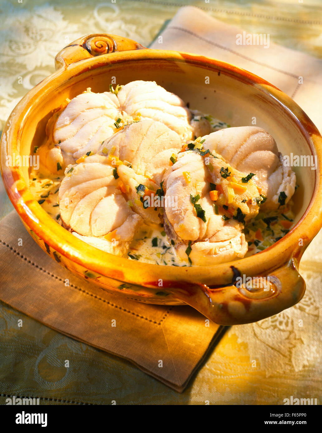Monfish and vegetables in creamy sauce Stock Photo