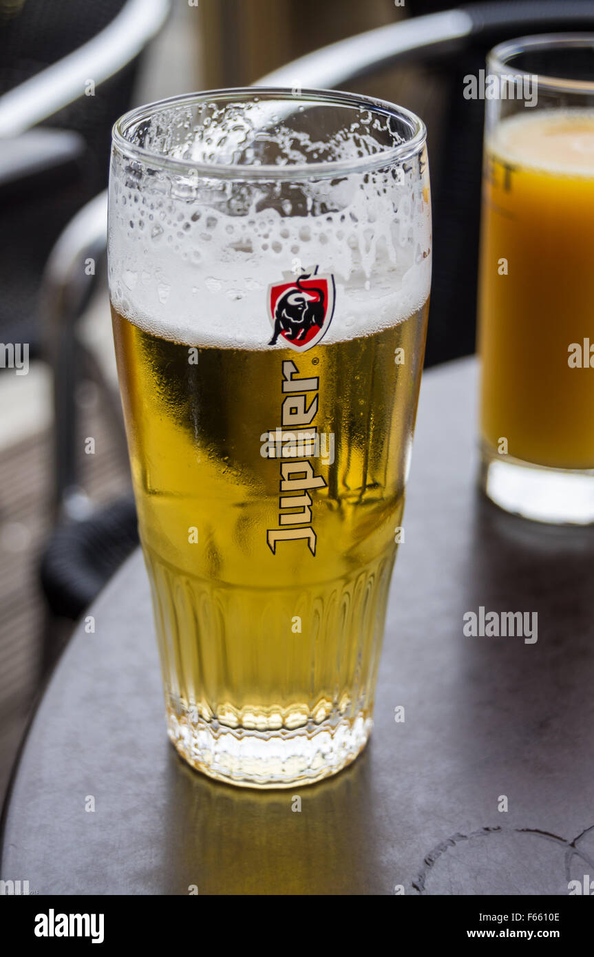 A printed glass of Jupiler lager beer on a bar table, Bergues, Nord Pas de Calais, Hauts de France, France pub table drinks glasses Stock Photo