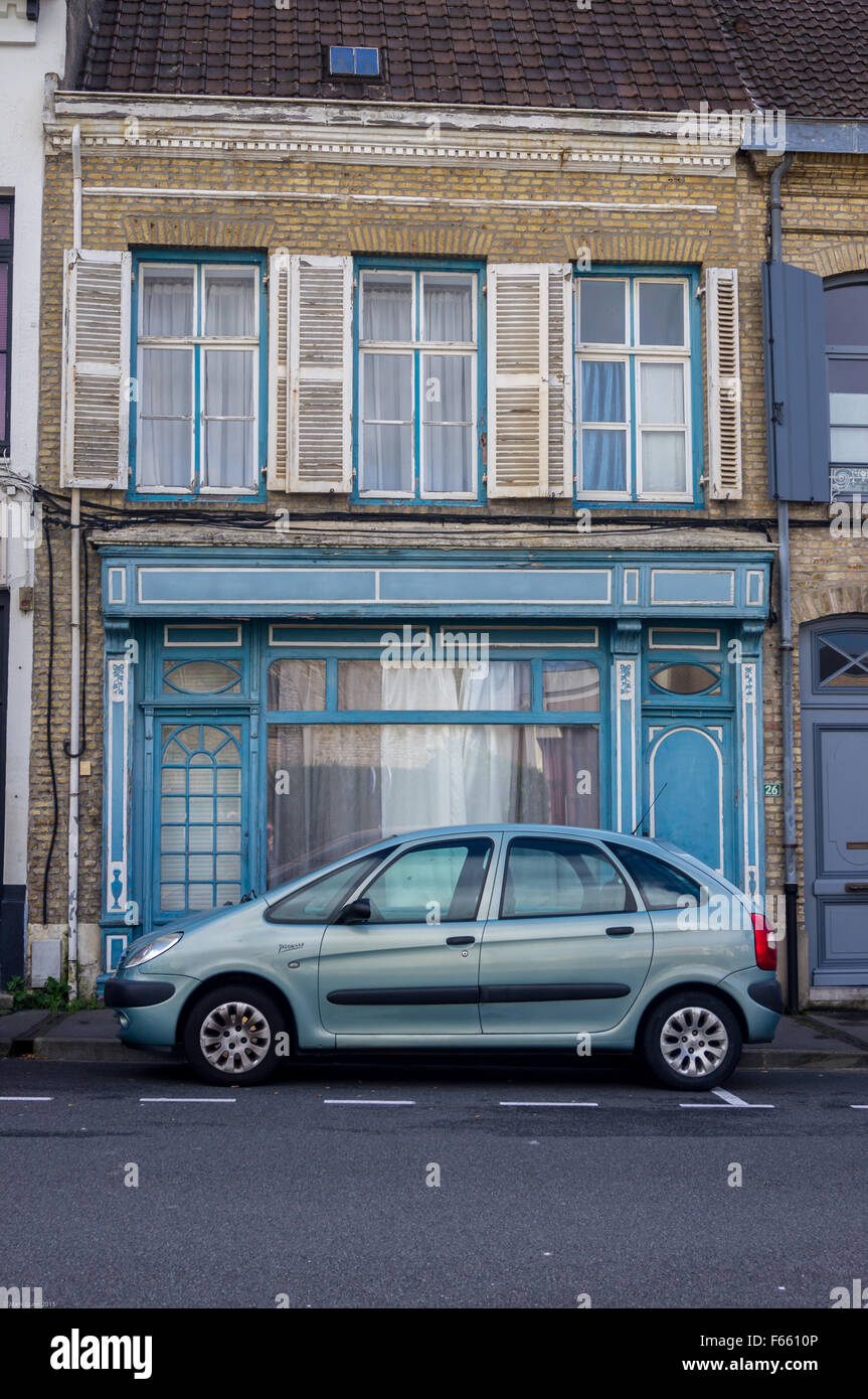 A metallic blue Citroen Picasso car parked outside a traditional Flemish terraced house,  Bergues, Nord Pas de Calais, France Stock Photo
