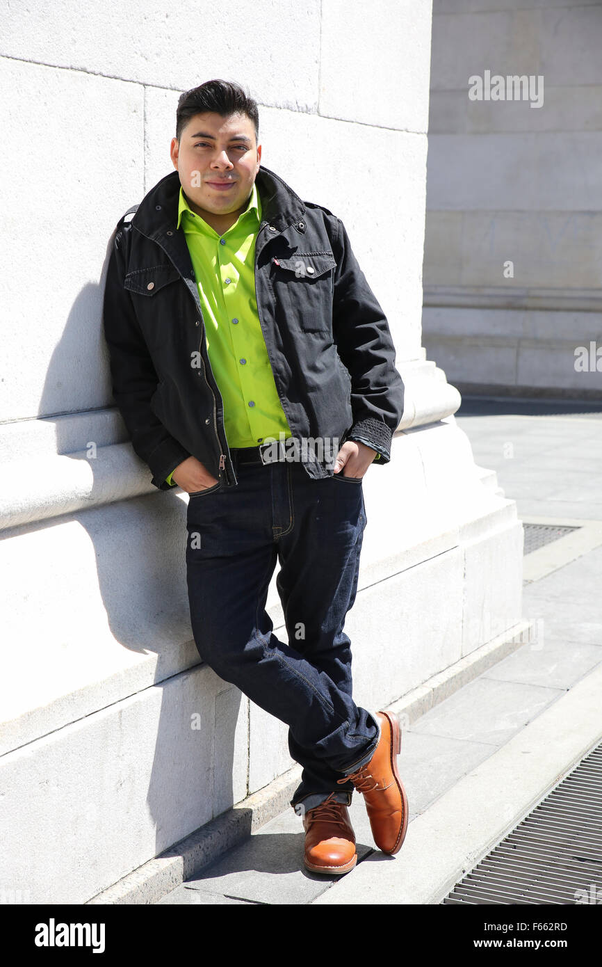 Portrait of a young man wearing a green shirt with a light black jacket  looking directly at the camera Stock Photo - Alamy