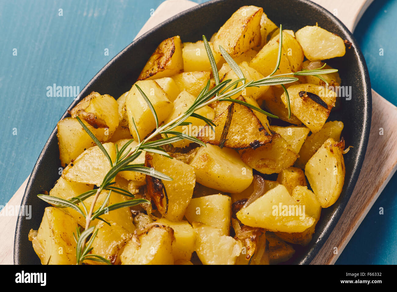 roasted potatoes iwith onion and rosemary in a cast iron pan over a