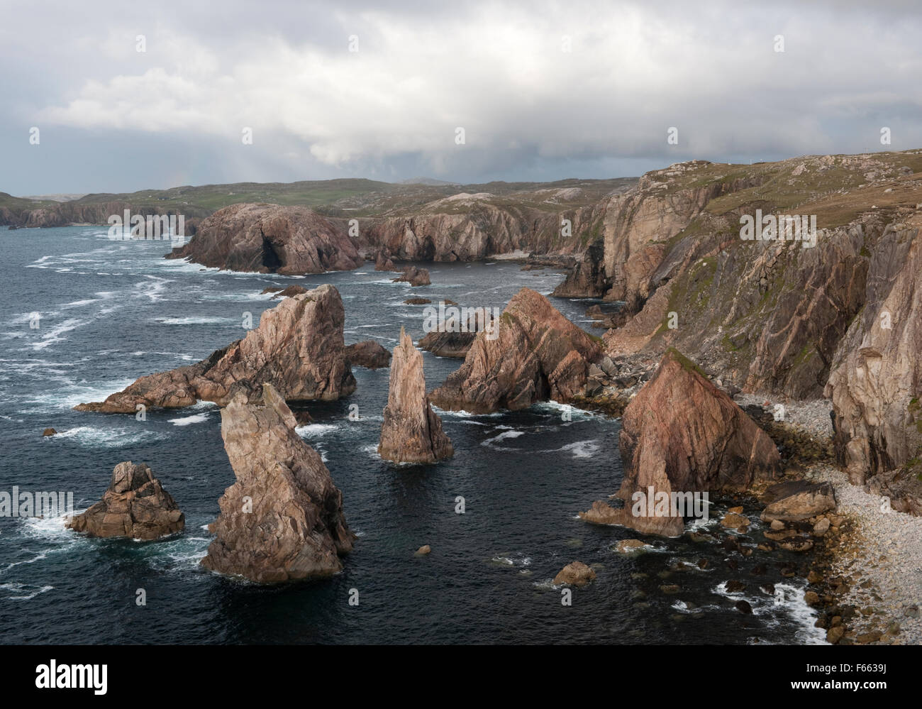 Geodh 'an Fhithich: a group of sea stacks formed by erosion of cliffs SW of Mangersta beach & Rubh 'an Taroin headland (rear L), Isle of Lewis. Stock Photo