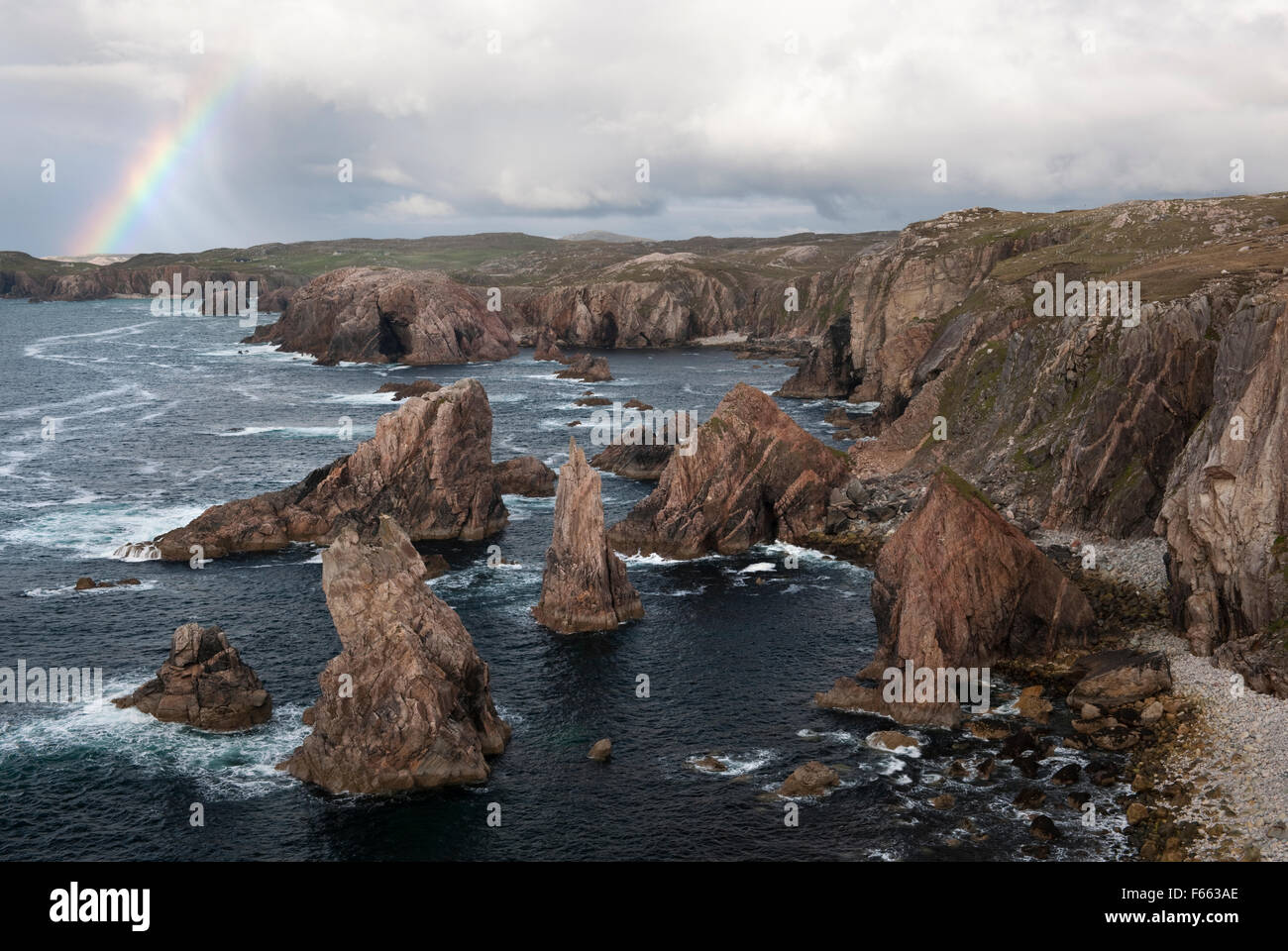 Geodh' an Fhithich: a group of sea stacks formed by erosion of cliffs SW of Mangersta beach & Rubh' an Taroin headland with rainbow, Isle of Lewis. Stock Photo