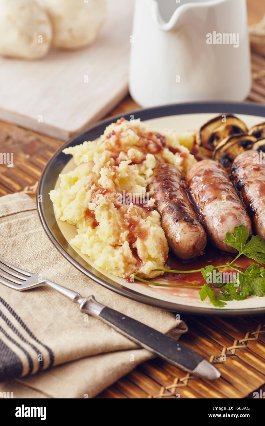 Sausage and mash dish with grilled mushrooms and tomatoes Stock Photo