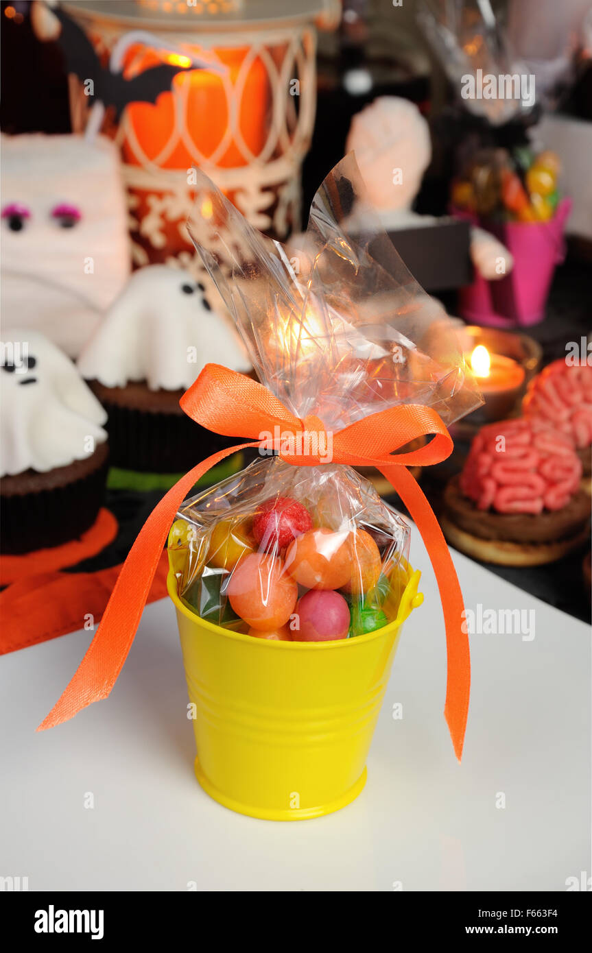 bucket filled with candy table among sweets for Halloween Stock Photo