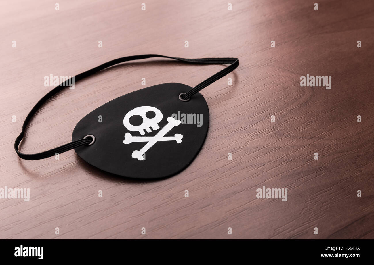 A closeup of pirate eyepatch on the wooden table Stock Photo